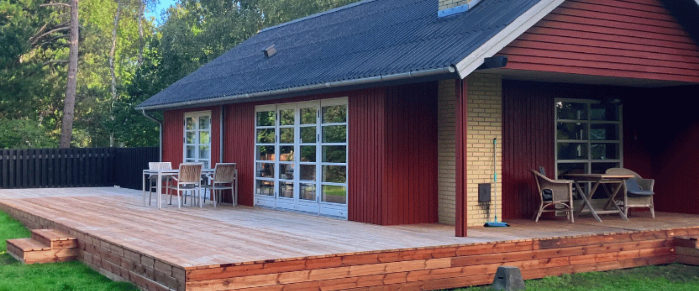Træterrasse ved et sommerhus med udsigt over vandet